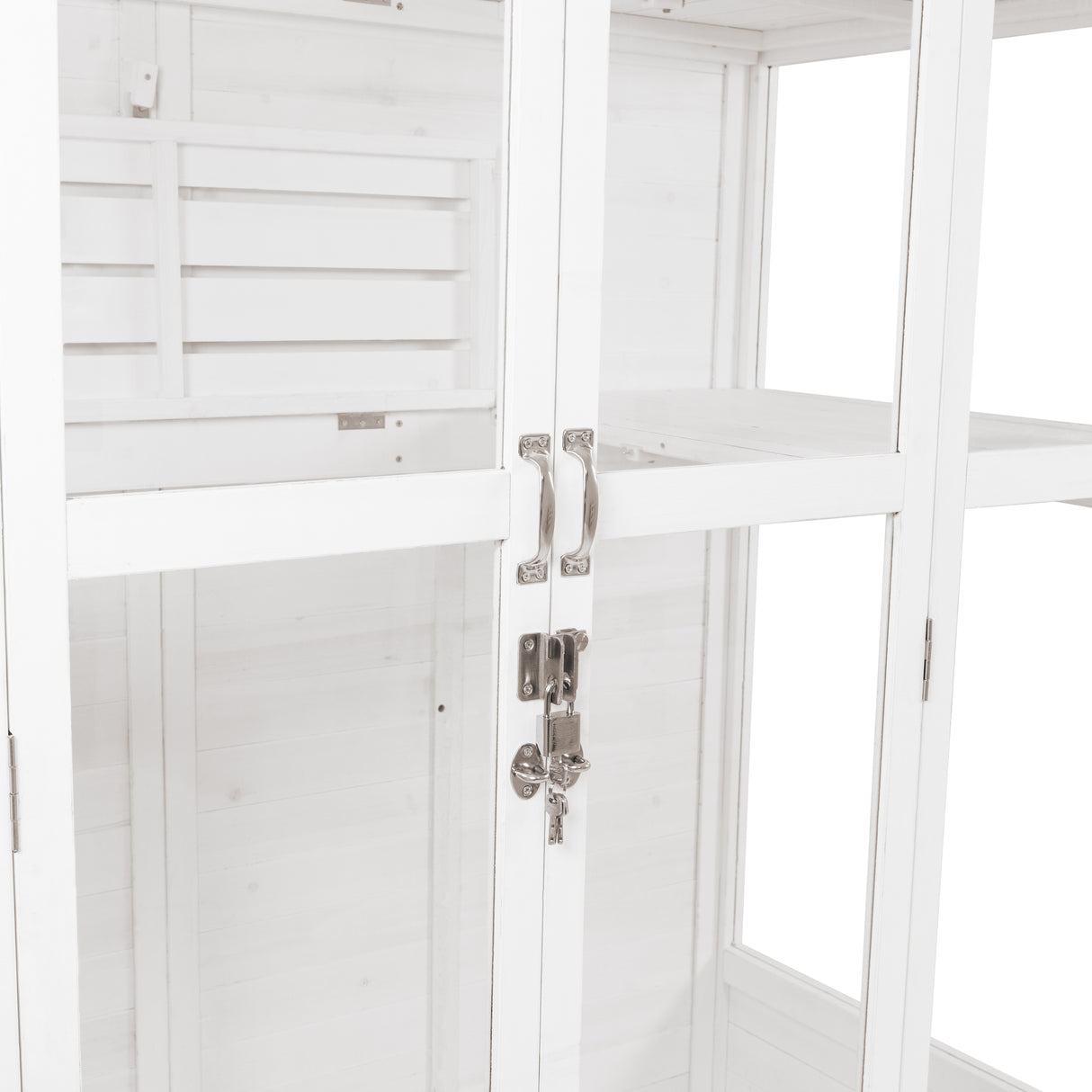 Vitt viktorianskt växthus med glasdörrar, metallhandtag och lås, inuti hyllor för växter och dekorationer, elegant design