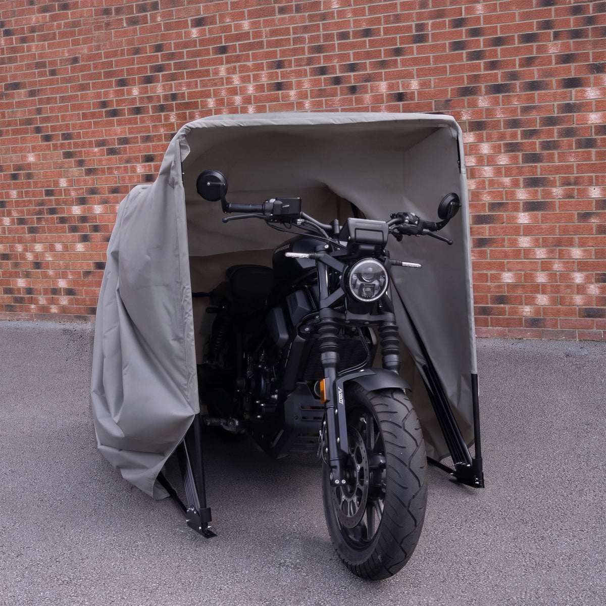 Medelstort grått motorcykelgarage med en motorcykel inuti, skyddande tyg och stabila ställningar, perfekt för utomhusbruk