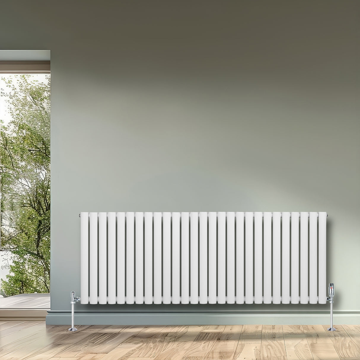 Oval vit enkelpelarradiator med släta ribbor, 600 mm x 1620 mm, placerad mot en grön vägg med fönster och trägolv