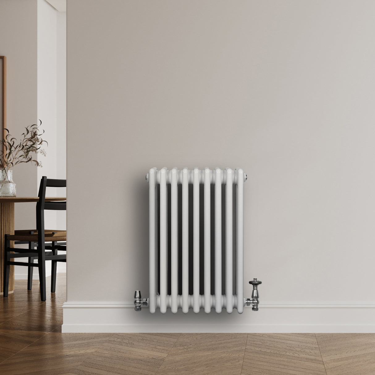 Traditionell vit 4-kolonnsradiator med släta ytor och rundade kanter, placerad mot en ljus vägg i ett modernt rum
