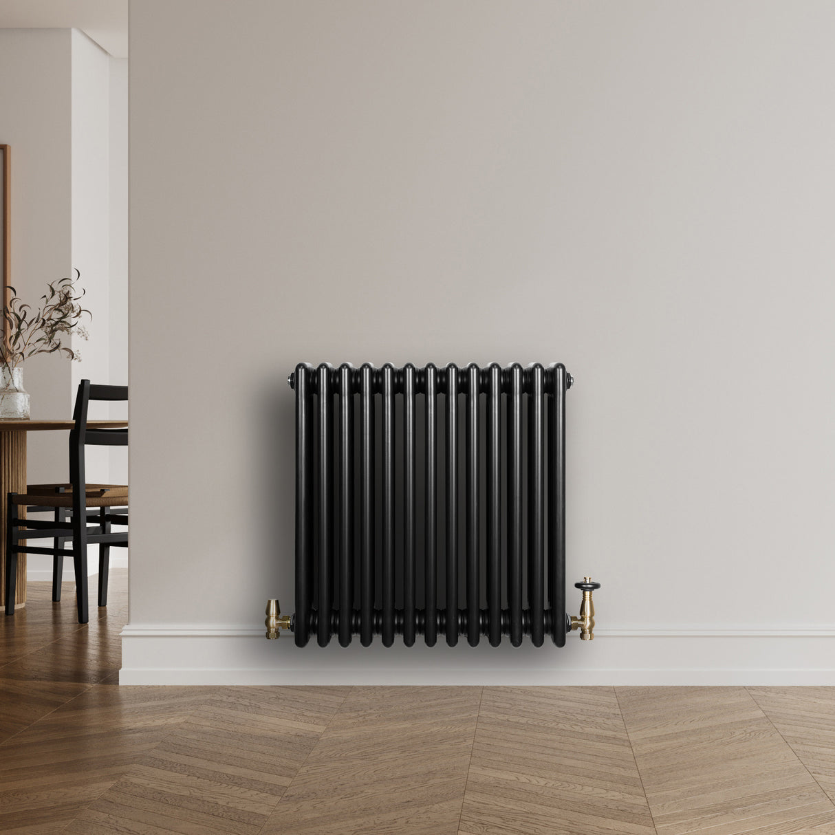 Svart traditionell 4-kolonnsradiator med släta ytor och glänsande finish, placerad mot en ljus vägg i ett modernt rum