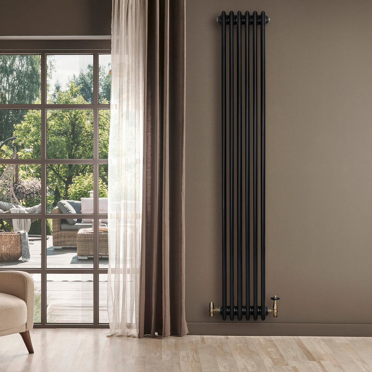 Svart traditionell 4-kolonnsradiator i metall, 1800 x 290 mm, installerad på vägg med trädetaljer och ljusa gardiner i bakgrunden