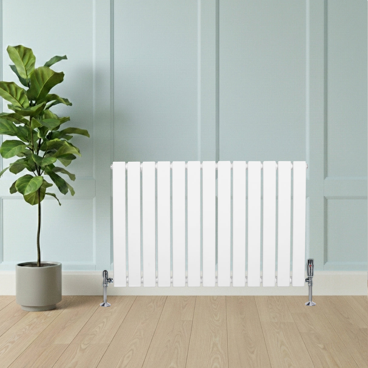 Platt enkelpelarradiator i vitt, 600 x 910 mm, med släta ytor och kromade ventiler, placerad framför en grön växt mot en ljus vägg