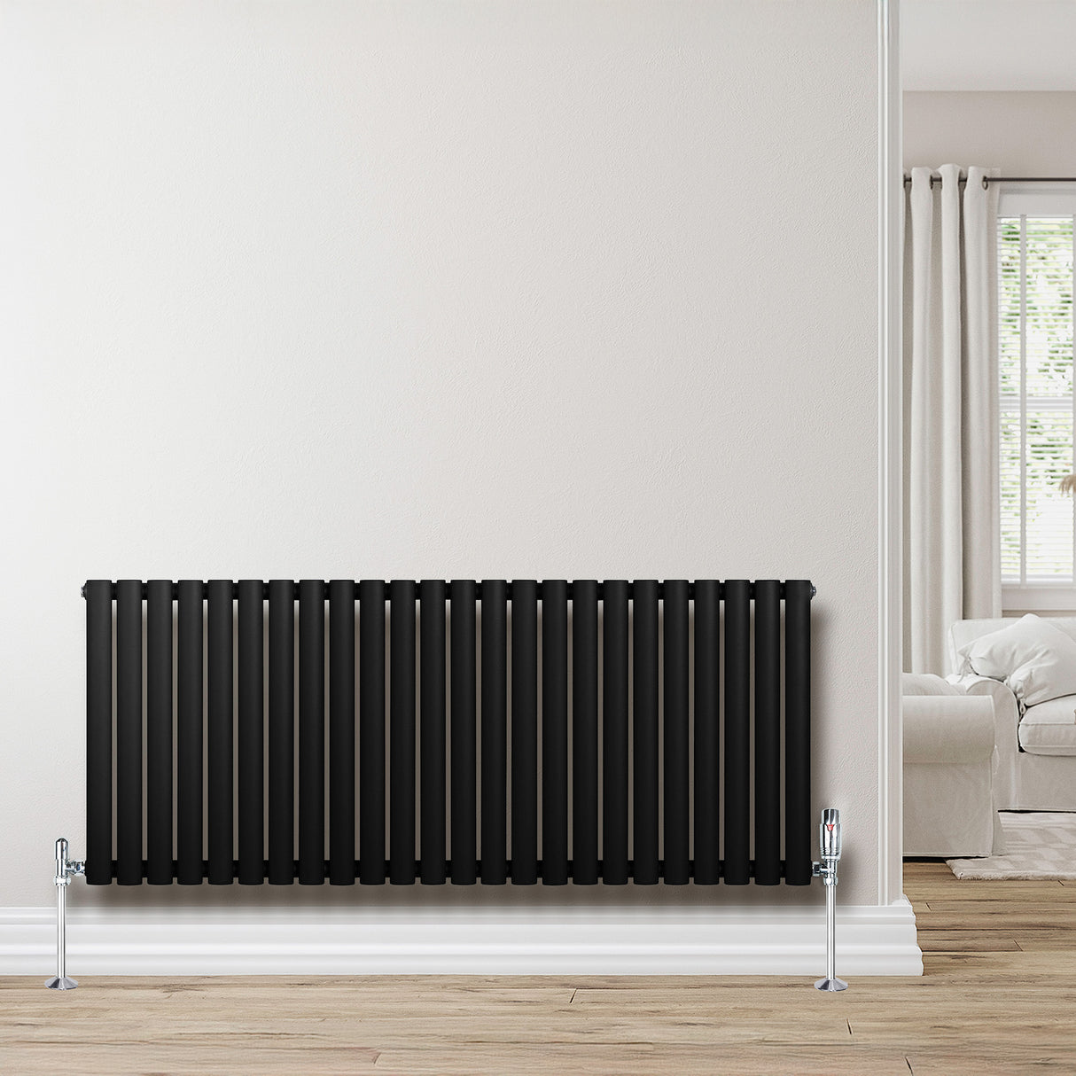 Oval svart enkelpelarradiator i metall, 600 x 1440 mm, med släta ytor och moderna linjer, placerad mot en ljus vägg