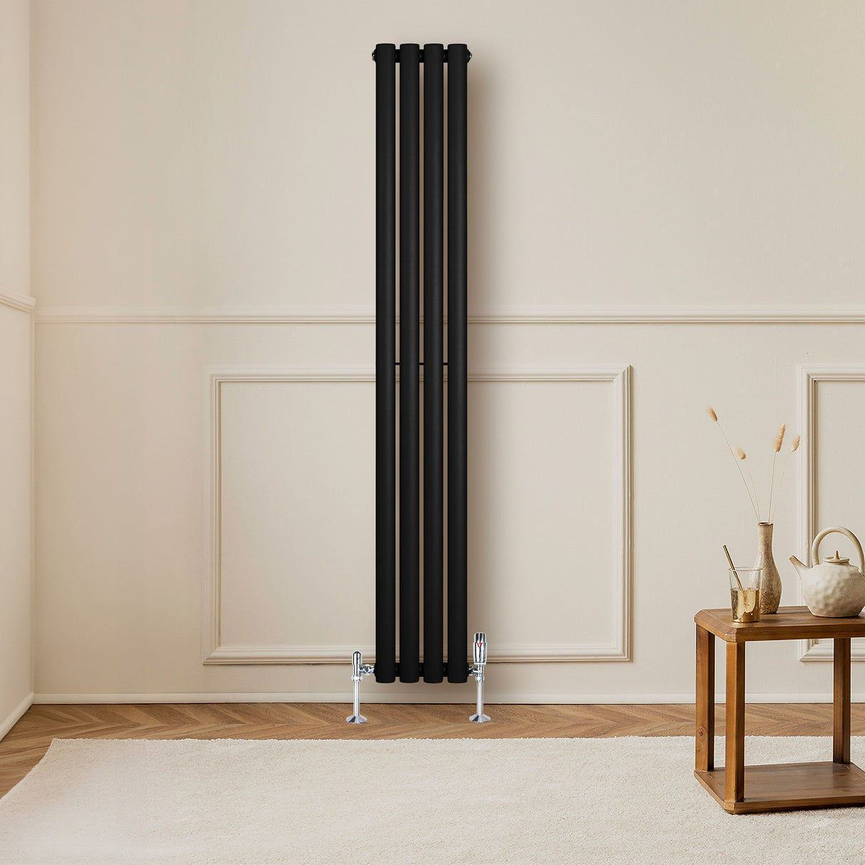 Oval enkelpelarradiator i svart, 1600 x 240 mm, med släta ytor och eleganta linjer, placerad mot en ljus vägg i ett modernt rum