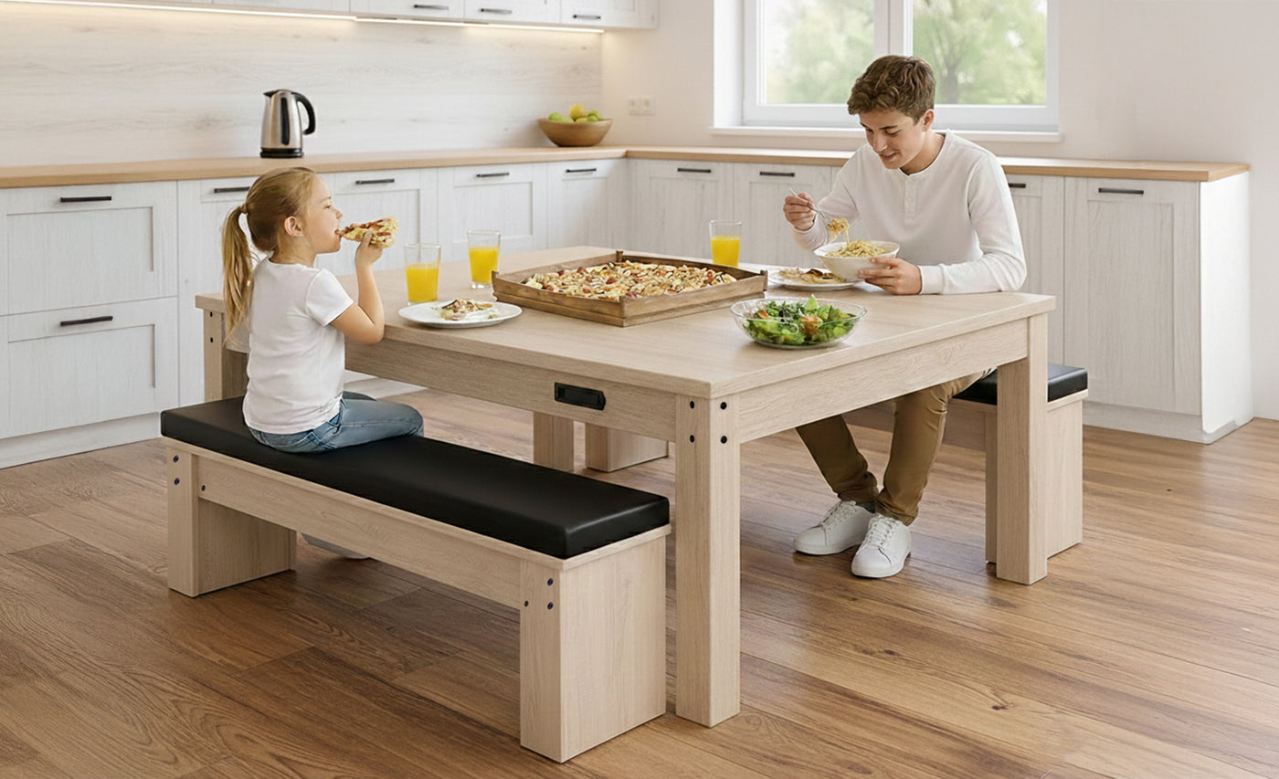 En ljus trämatta med svarta bänkar, där en man och en flicka njuter av en måltid med pizza och drycker i ett modernt kök