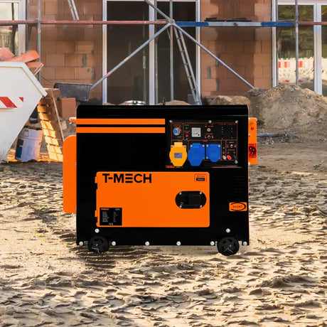 Svart och orange generator med kontroller, placerad på en byggarbetsplats med grus och byggmaterial i bakgrunden