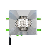 Reflekterande silverfärgad lampa med grönna detaljer, fyrkantig form och synlig inre struktur av metallgaller och spegelytor