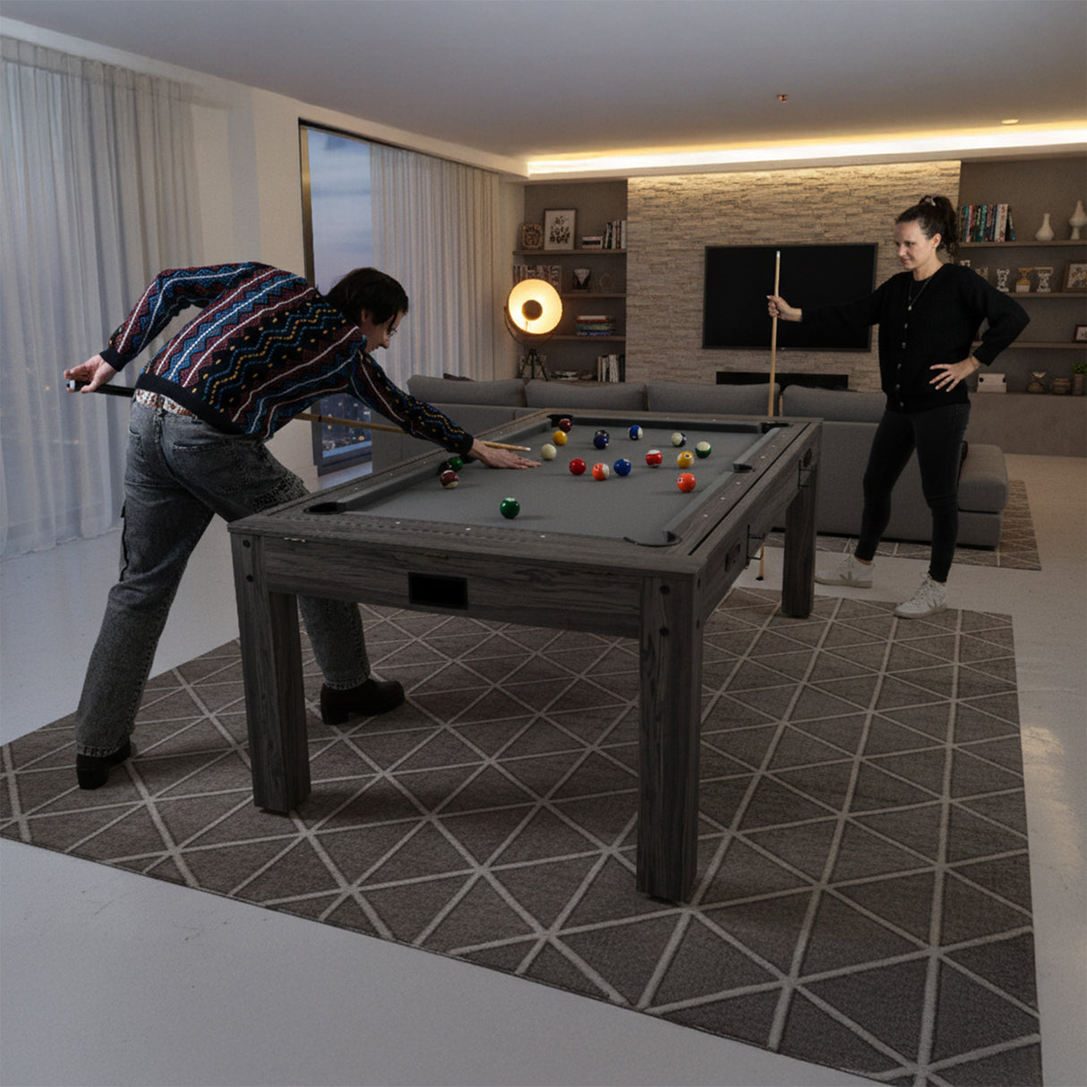 Grått 7-i-1 spelbord med biljard, dart och bordtennis, omgiven av moderna möbler och en mjuk, geometrisk matta