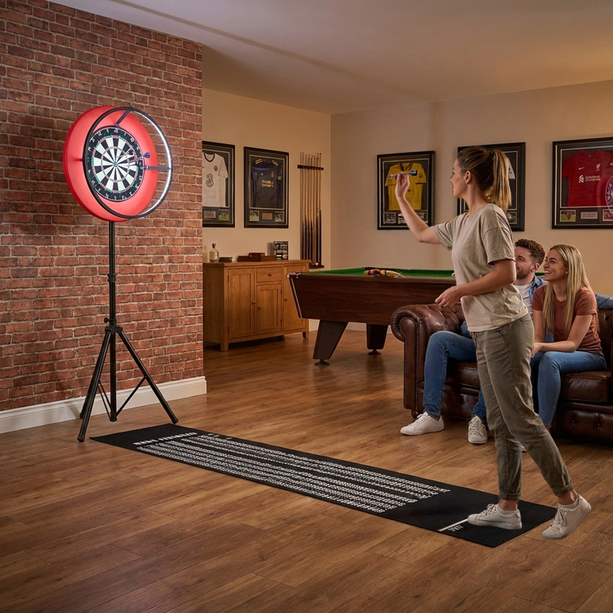 Grått spelbord med dartpaket och LED-lampa, en kvinna kastar dartpilar mot en röd darttavla i en mysig inomhusmiljö