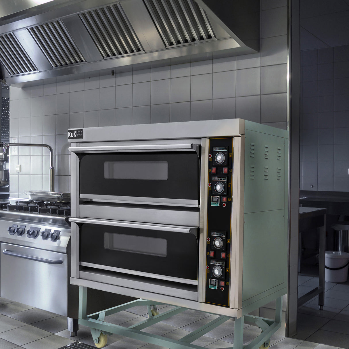 Professionell pizzaugn med två ugnar, rostfritt stål, svart glasdörrar och kontroller för temperatur och tid, placerad i ett modernt kök