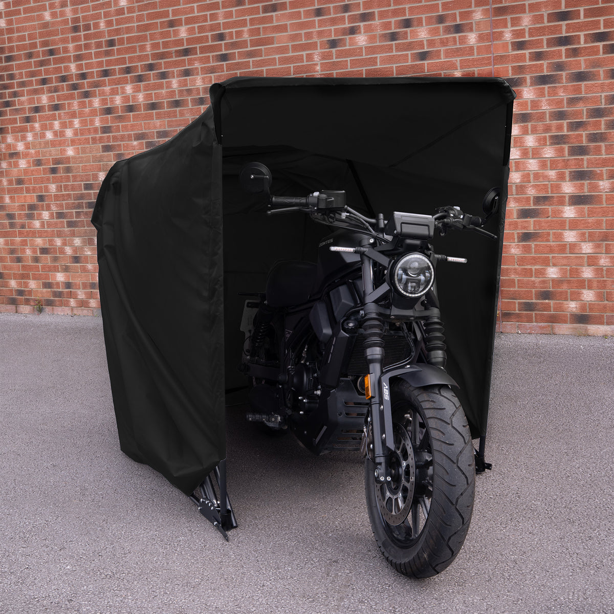 Svart motorcykel skyddad av en svart tältliknande struktur, med en modern design och kraftfulla linjer, placerad på en grå asfalt yta