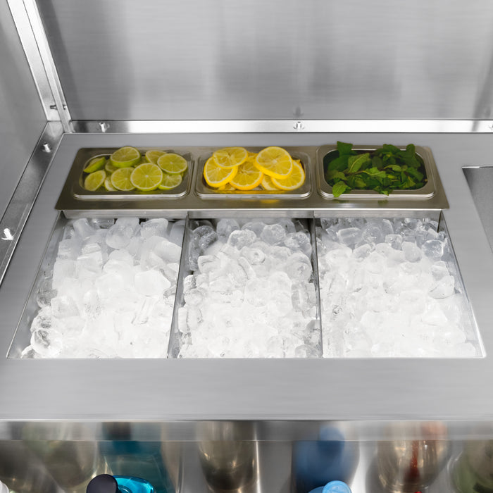 Kylbox med is, skivade citroner och lime samt färsk mynta, i en rostfri behållare med tre sektioner för drinktillbehör