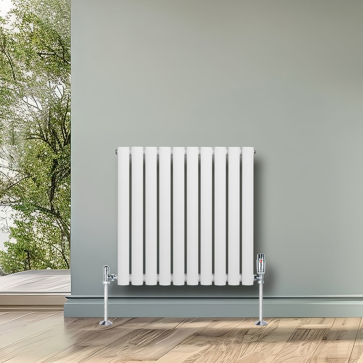 Oval vit enkelpelarradiator med sju vertikala ribbor, monterad på golvet, med moderna ventiler och träparkett i bakgrunden