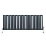 Oval enkelkolonnsradiator i antracitgrå med släta ytor och vertikala ribbor, monterad med kromade ventiler och fötter