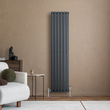 Oval enkelkolonnsradiator i antracitgrå, 1600 mm x 360 mm, med släta ytor och moderna ventiler, placerad mot en beige vägg