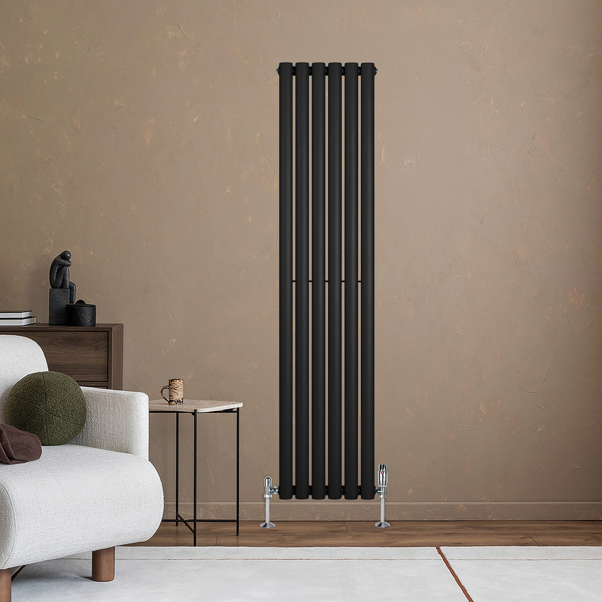 Svart oval enkelkolonnsradiator med sex vertikala ribbor, monterad på en beige vägg, kompletterad med kromade ventiler