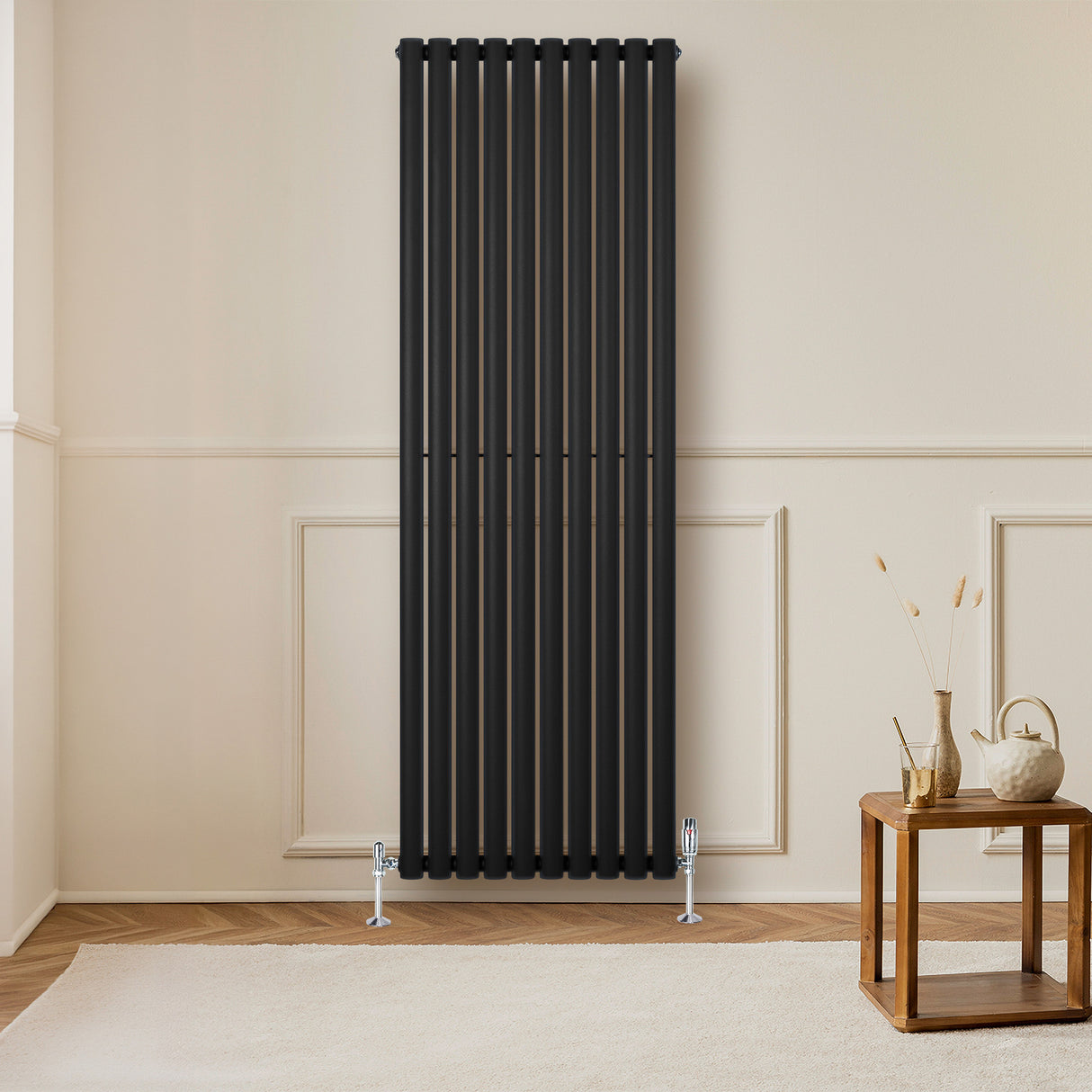 Oval svart enkelkolonnsradiator med ventiler, 1800 mm x 600 mm, placerad på en ljus vägg i ett modernt rum med trädetaljer