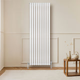 Oval vit enkelpelarradiator, 1800 mm x 600 mm, med släta ytor och vertikala ribbor, placerad mot en ljus vägg i ett rum