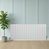 Platt vit enkelkolumnsradiator med ventiler, 600 mm x 1400 mm, placerad framför en grön växt i en modern inredning