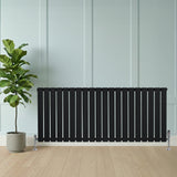 Svart platt enkelkolumnsradiator med ventiler, 600 mm x 1400 mm, placerad mot en ljus vägg, med en grön växt i kruka bredvid