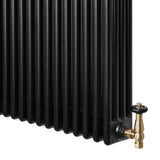 Svart traditionell 4-kolonnsradiator med vertikala ribbor och en mässingsventil i nedre hörnet, elegant och funktionell design