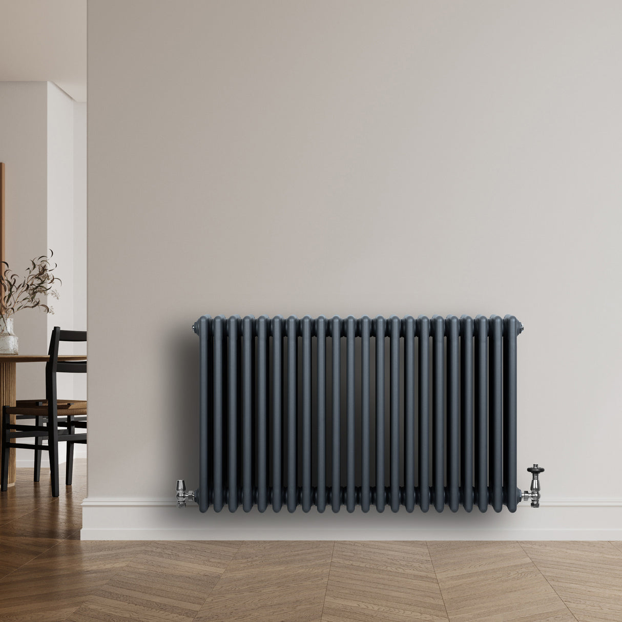 Traditionell 4-kolonnsradiator i antracitgrå, med släta ytor och vertikala rör, installerad på en ljus vägg i modern inredning