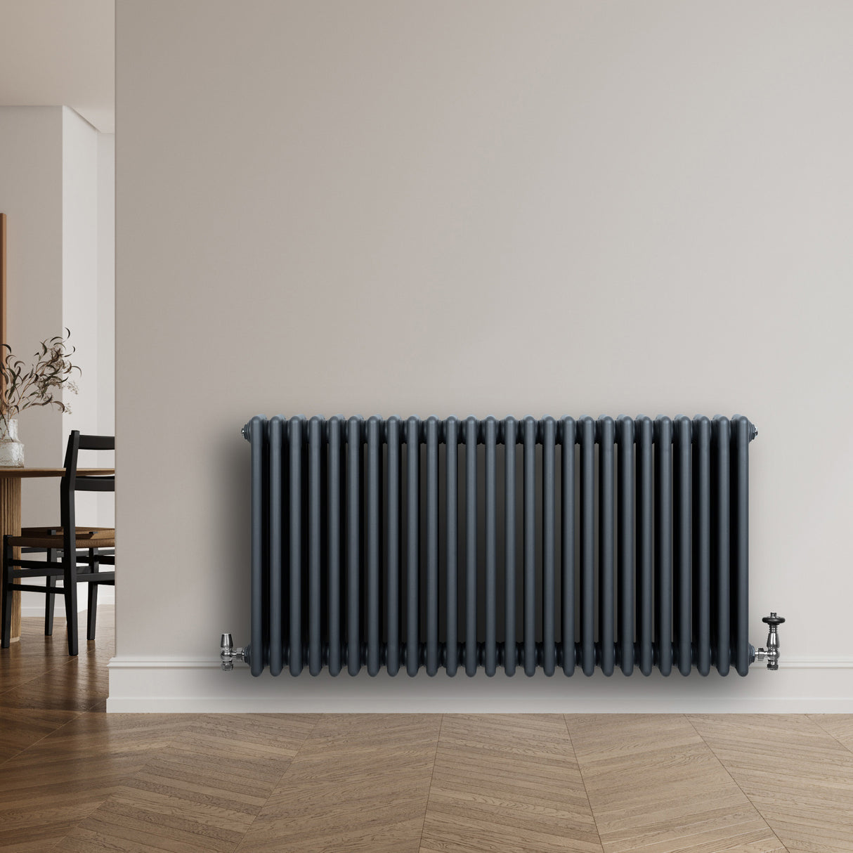 Traditionell 4-kolonnsradiator i antracitgrå, 600 x 1190 mm, med släta ytor och rundade kanter, placerad mot en vägg