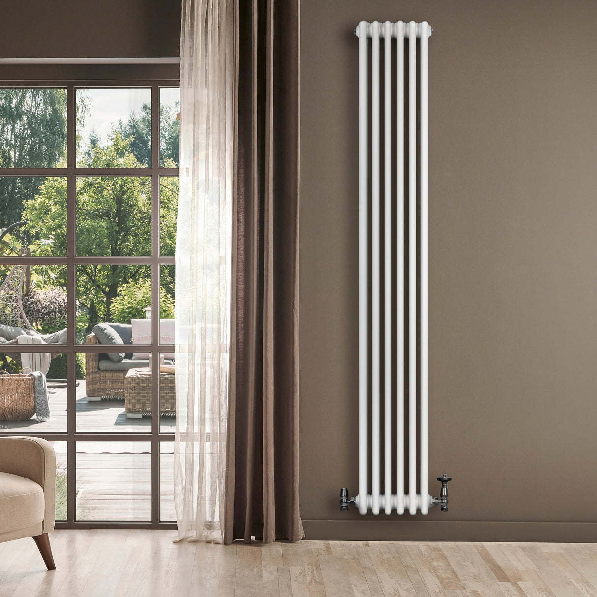 Vit traditionell 4-kolonnsradiator med släta ytor, installerad på en vägg, omgiven av naturligt ljus och moderna möbler