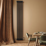 Traditionell svart 4-kolonnsradiator i metall, monterad på vägg, med ventiler och elegant inredning i bakgrunden