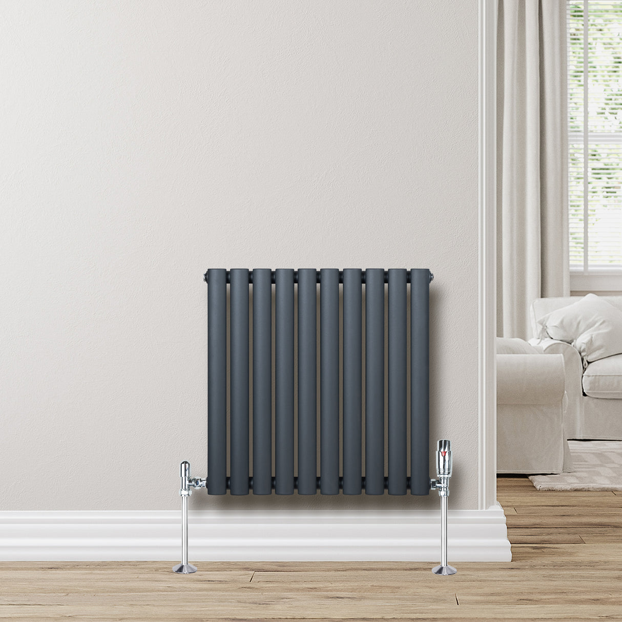 Oval enkelkolonnsradiator i antracitgrå, 600 mm x 600 mm, med glänsande ventiler och släta, vertikala rör monterad på vägg