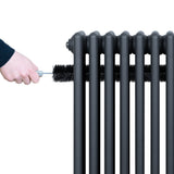 Traditionell antracitgrå 4-kolonnsradiator med släta ytor, rengörs med en borste för att hålla den i gott skick