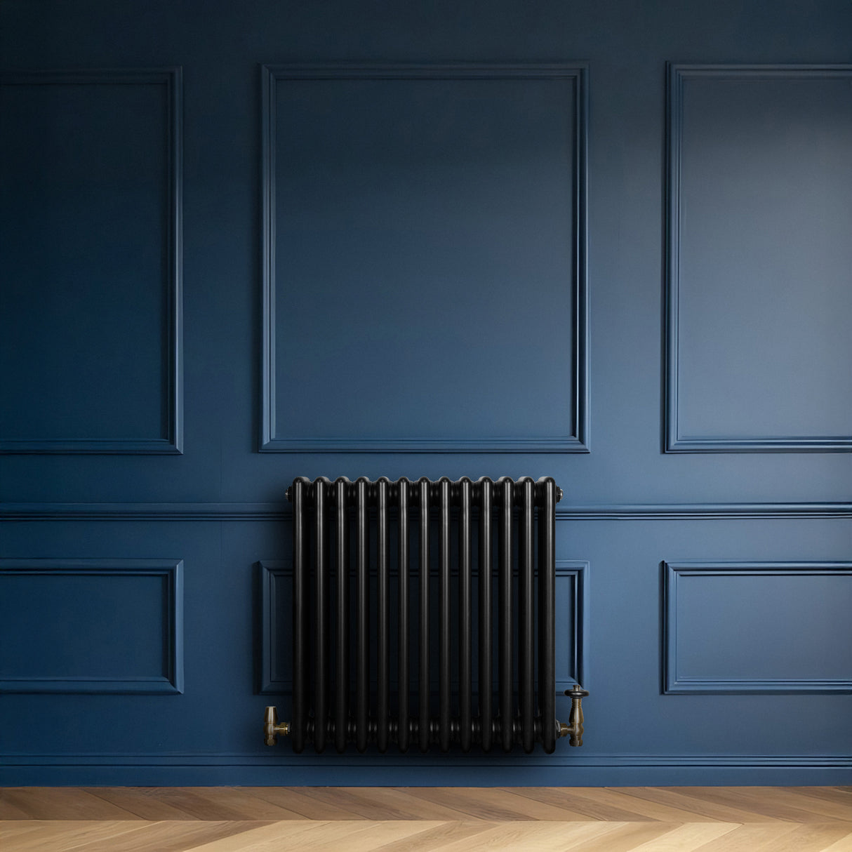 Svart traditionell 4-kolonnsradiator i elegant design, placerad mot en mörkblå vägg med träpanel och fiskbensmönstrad golv