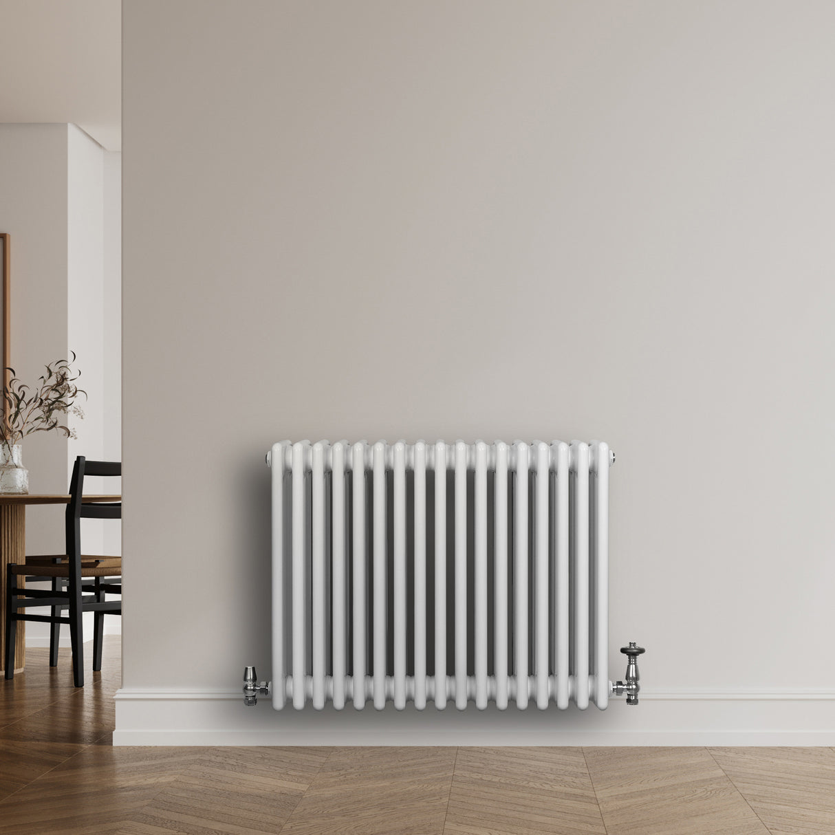 Traditionell vit 4-kolonnsradiator med släta ytor, rundade kanter och synliga anslutningar, placerad mot en ljus vägg