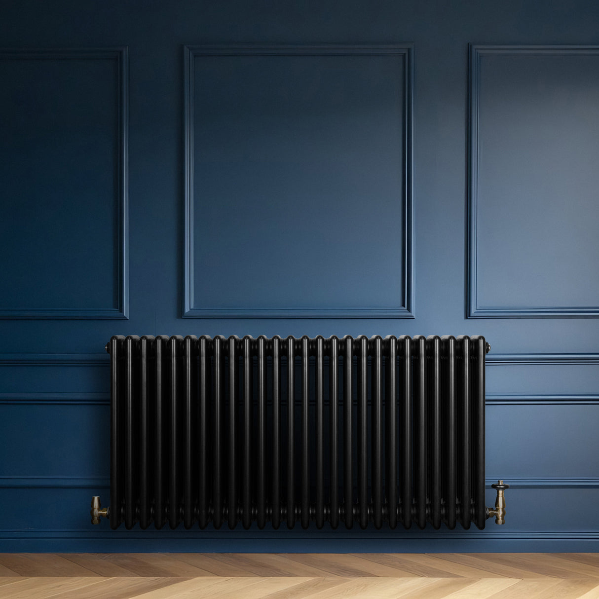 Svart traditionell 4-kolonnsradiator med släta ytor, placerad mot en blå vägg, kompletterad med eleganta golvplankor