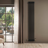 Svart traditionell 4-kolonnsradiator i metall, 1800 x 290 mm, installerad på vägg med trädetaljer och ljusa gardiner i bakgrunden
