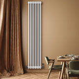 Traditionell vit 4-kolonnsradiator i metall, 1800 x 380 mm, monterad på vägg med mjuka, neutrala färger i rummet