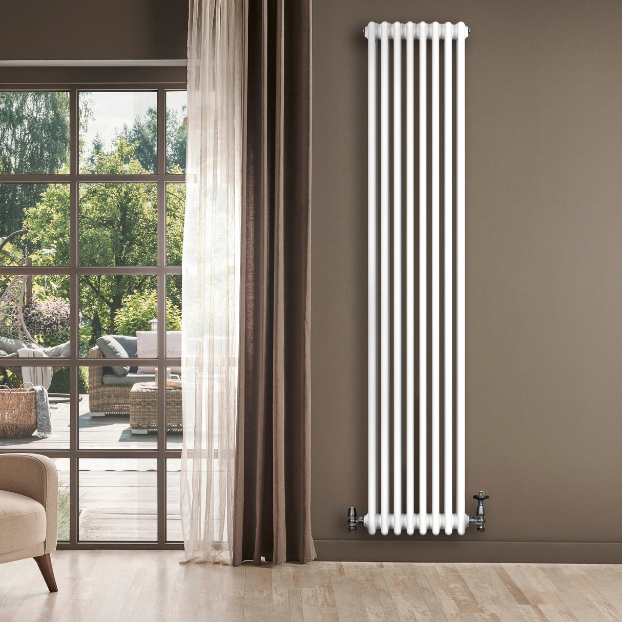 Traditionell vit 4-kolonnsradiator i metall, 1800 x 380 mm, placerad vid ett fönster med utsikt över en grönskande trädgård