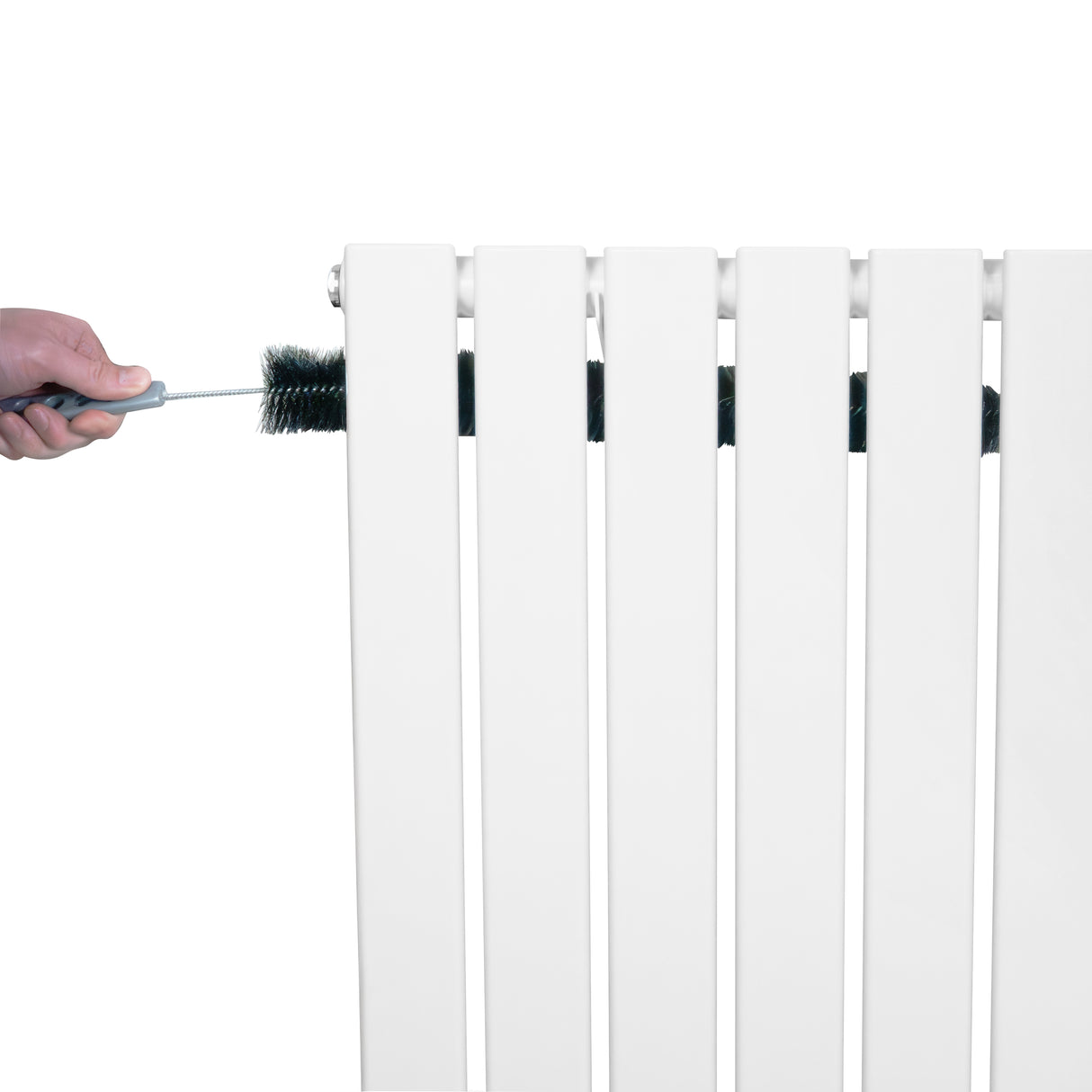 Vit platt enkelpelarradiator i 600 x 910 mm med en hand som rengör radiatorns ribbor med en borste
