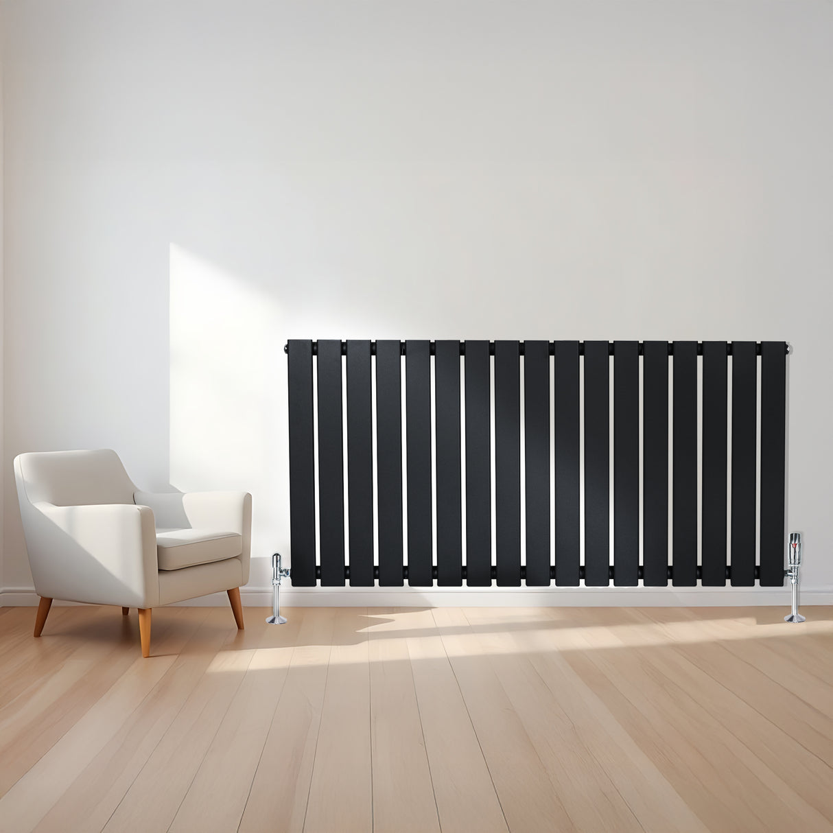 Svart platt enkelpelarradiator med vertikala ribbor, placerad mot en ljus vägg, intill en modern fåtölj på ett trägolv