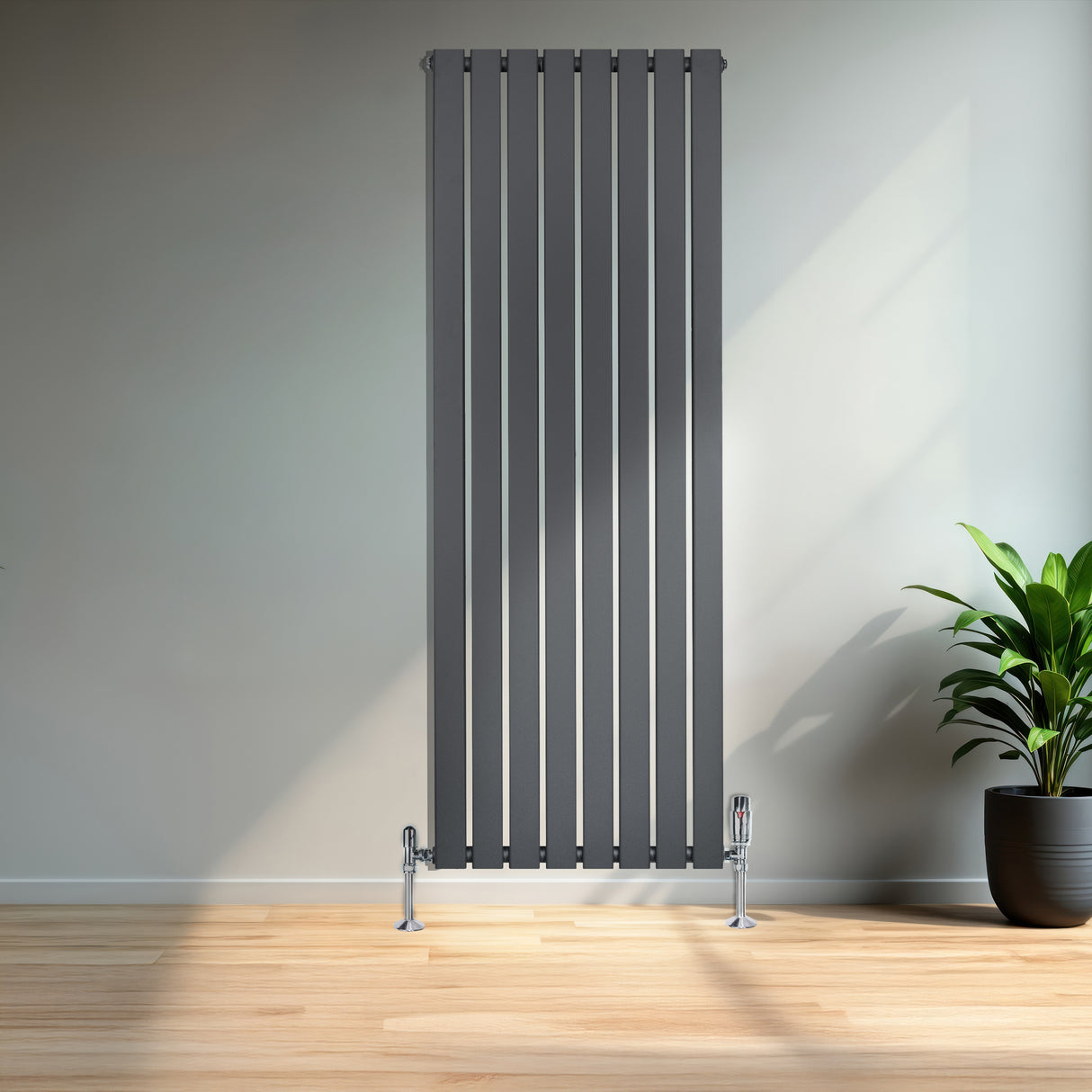 Platt enkelpelarradiator i antracitgrå, 1600 x 560 mm, med slanka vertikala lameller och glänsande fötter, placerad mot en vägg