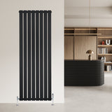 Svart platt enkelpelarradiator med vertikala lameller, 1600 x 560 mm, installerad på vägg i modern inredning med stilren design