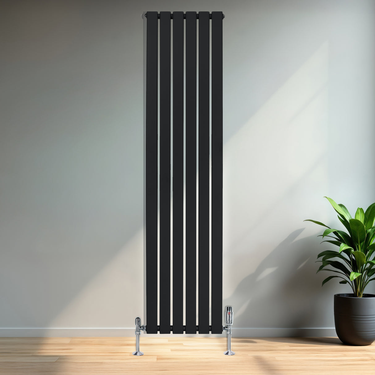 Svart platt enkelpelarradiator med fem vertikala ribbor, installerad på en vägg i ett rum med ljusa trädetaljer och en grön växt
