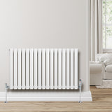 Oval enkelpelarradiator i vit färg, 600 x 1020 mm, med släta ytor och kromade ventiler, placerad mot en ljus vägg i ett rum