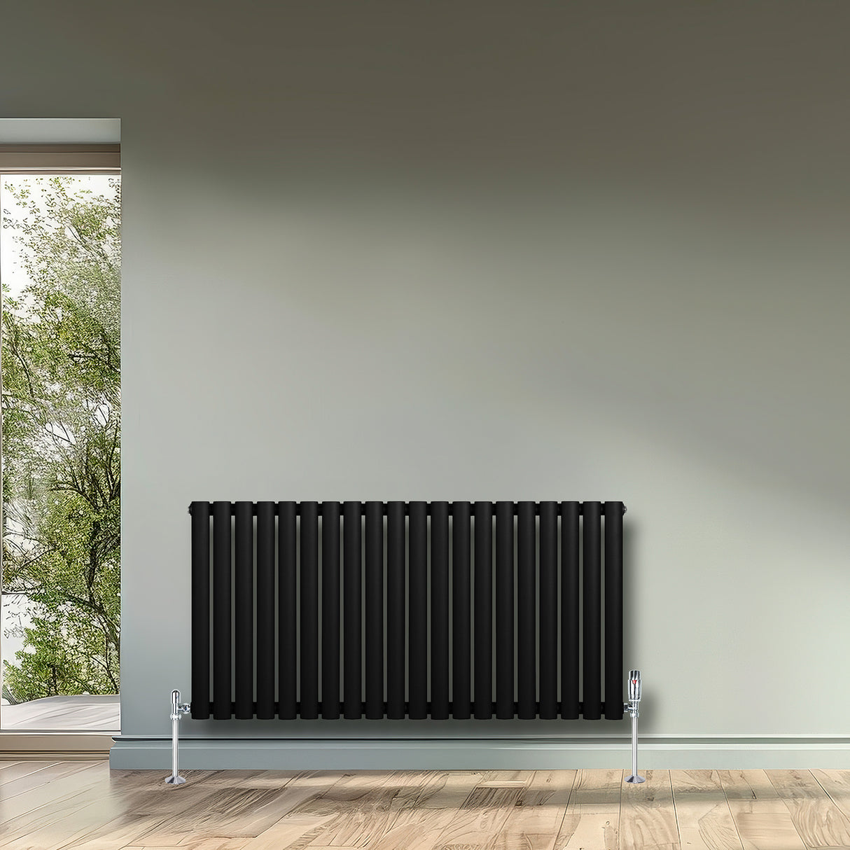 Oval enkelpelarradiator i svart, 600 x 1200 mm, med släta ytor och stilren design, placerad på en ljus vägg i ett rum med fönster