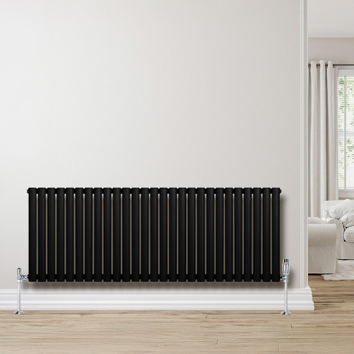 Oval enkelpelarradiator i svart, 600 x 1620 mm, med släta ytor och stilren design, placerad mot en ljus vägg i ett modernt rum