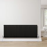 Oval enkelpelarradiator i svart, 600 x 1620 mm, med släta ytor och stilren design, placerad mot en ljus vägg i ett modernt rum