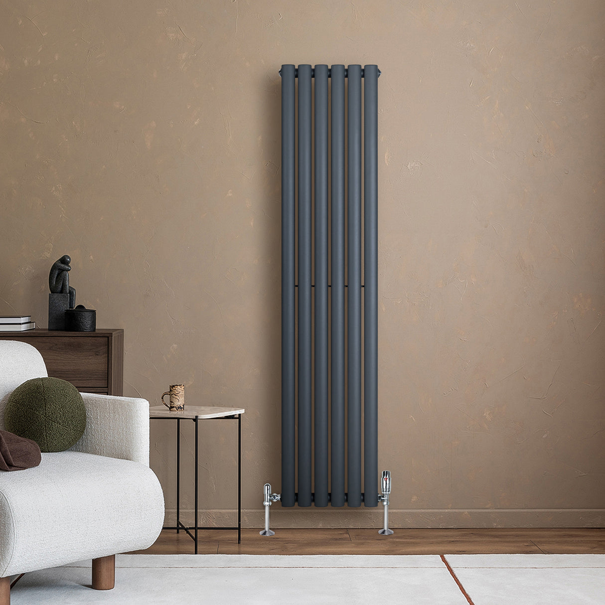 Oval enkelpelarradiator i antracitgrå, 1600 x 360 mm, med släta, moderna linjer och stilren design mot en beige vägg