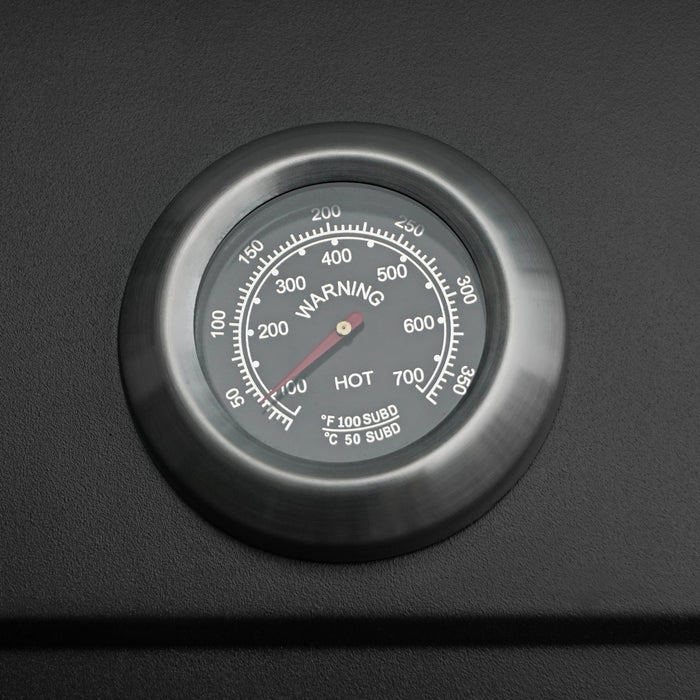 Termometer med svart bakgrund, rostfritt stålram, tydlig skala som visar temperatur från 50 till 600 grader Fahrenheit