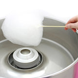 Söt, fluffig sockervadd på en träpinne, med en glänsande metallmaskin i bakgrunden, perfekt för festligheter och nöjen